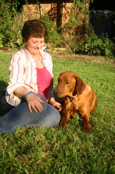 Gus sitting near stables with Janice
